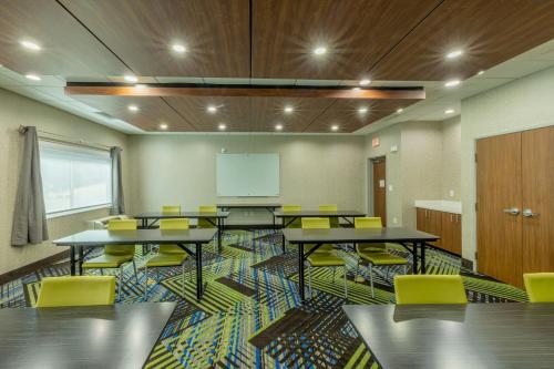 a classroom with tables and yellow chairs and a whiteboard at Holiday Inn Express & Suites - Lindale by IHG in Lindale