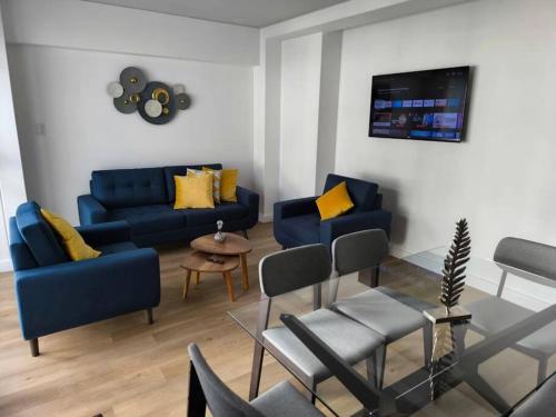 a living room with two blue couches and a table at Departamento de estreno en zona exclusiva Cayma in Cayma