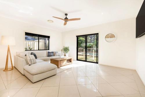 a living room with a couch and a ceiling fan at The Atrium by Experience Jervis Bay in St Georges Basin