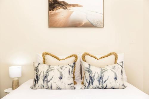 a bedroom with a bed with two pillows at The Atrium by Experience Jervis Bay in St Georges Basin