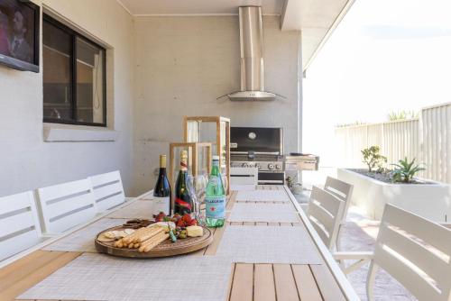 a dining room table with a plate of food on it at The Atrium by Experience Jervis Bay in St Georges Basin