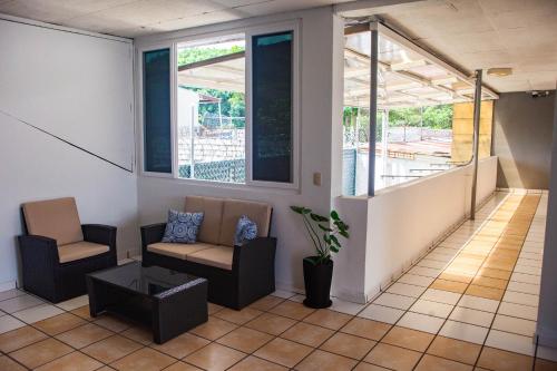 Una sala de estar con dos sillas y un sofá. en Hotel Casa Manantiales, en Mexicanos