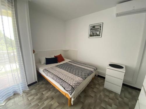 une chambre avec un lit dans une pièce blanche dans l'établissement Studio cosy avec balcon, proche des Thermes, animaux admis, climatisé, classé 2 étoiles - FR-1-503-180, à Balaruc-les-Bains
