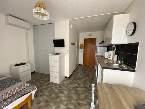 une chambre avec un lit et une cuisine avec un évier dans l'établissement Studio cosy avec balcon, proche des Thermes, animaux admis, climatisé, classé 2 étoiles - FR-1-503-180, à Balaruc-les-Bains