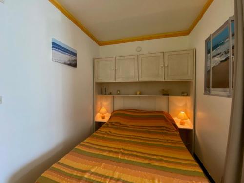 - une petite chambre avec un lit et deux lampes dans l'établissement Appartement cosy avec balcon et climatisation à Balaruc-les-Bains - FR-1-503-179, à Balaruc-les-Bains