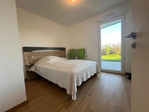 une chambre avec un lit et une grande fenêtre dans l'établissement Appartement cosy avec jardin et parking à Évian - FR-1-498-105, à Évian-les-Bains