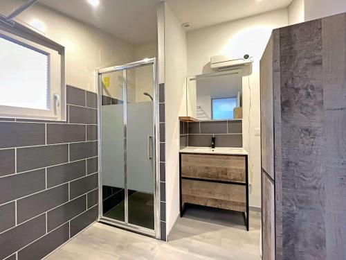 un bagno con doccia, lavandino e specchio di Maison entre ville et plage avec cour jardin - FR-1-646-78 a Berck-sur-Mer