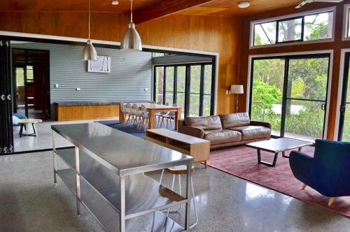 a living room with a table and a couch at Aranakie- 7 Grey Street South West Rocks NSW 2431 in Arakoon