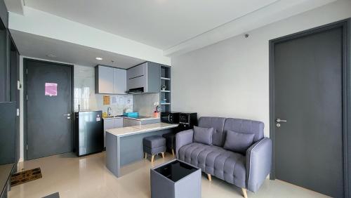 a living room with a couch and a kitchen at Palam Mansion at Apartment One Residence in Batam Center