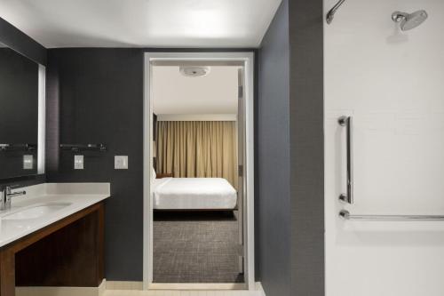 a bathroom with a sink and a bed in a room at Residence Inn by Marriott Tampa Wesley Chapel in Wesley Chapel
