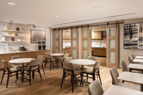 a restaurant with tables and chairs and a kitchen at Residence Inn by Marriott Tampa Wesley Chapel in Wesley Chapel