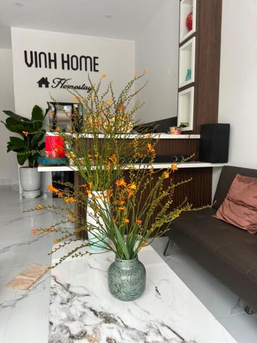 a vase with flowers on a table in a living room at Vinh Home Apartment in Quang Tri