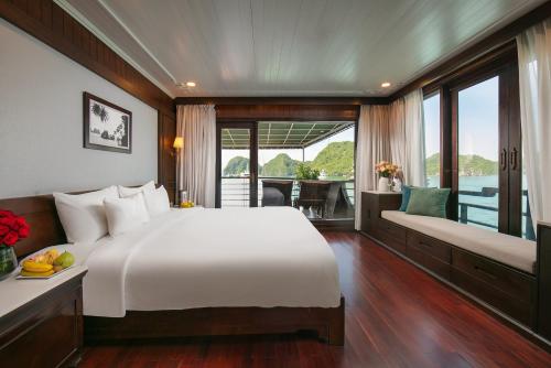 a bedroom with a large white bed and a balcony at Mila Cruises in Ha Long