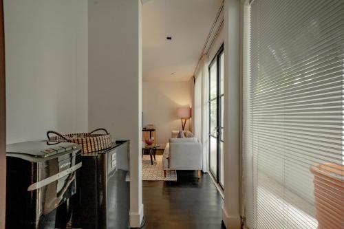 a hallway with white walls and a room with a window at Martini Suite and Villa in Kerobokan