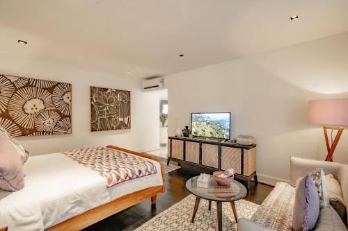 a living room with a bed and a tv at Martini Suite and Villa in Kerobokan