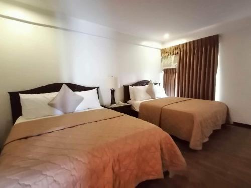 a hotel room with two beds and a window at Casa Cecilia Heritage Hotel in Taal