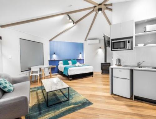 a living room with a bed and a kitchen at Koala Cabins Sunshine Coast in Mapleton