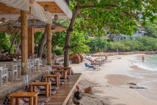 a beach with chairs and umbrellas and the ocean at Sai Daeng Resort in Koh Tao