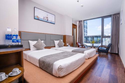 - 2 lits dans une chambre d'hôtel avec une grande fenêtre dans l'établissement DTX Hotel Nha Trang, à Nha Trang