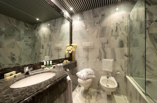 a bathroom with a sink and a toilet and a shower at Grand Hotel Barone Di Sassj in Sesto San Giovanni