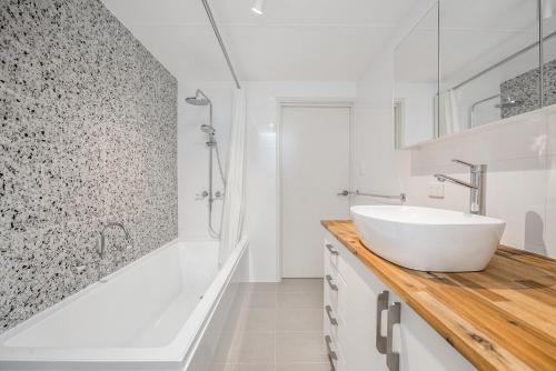 a white bathroom with a sink and a shower at Chateau McNally in Lancelin
