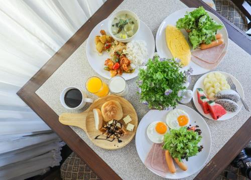 Eurana Boutique Hotel في شيانغ ماي: طاولة عليها العديد من أطباق الطعام
