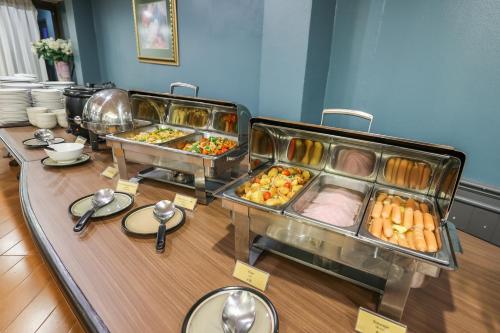 Eurana Boutique Hotel في شيانغ ماي: بوفيه مع عدة صواني طعام على طاولة