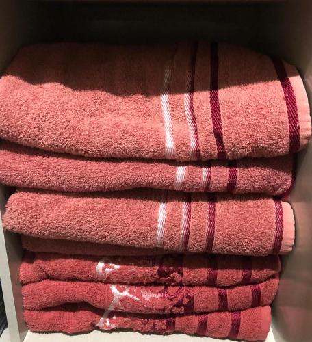 a pile of pink towels stacked on top of each other at CASA EM BH Santa Efigênia in Belo Horizonte
