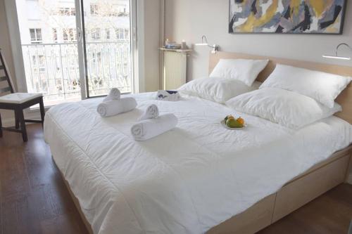 - un grand lit blanc avec deux animaux rembourrés dans l'établissement Elégant et lumineux à 500 m Paris Expo Porte de Versailles, à Issy-les-Moulineaux