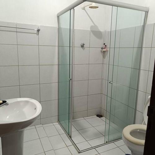 a bathroom with a shower and a toilet and a sink at Casa temporada in Baía Formosa