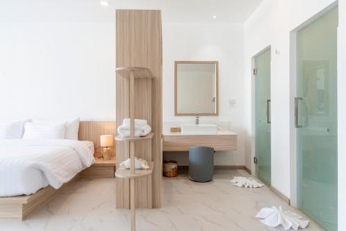 a bedroom with a bed and a sink and a mirror at Beachfront Luxury Apartment 33 in Bang Rak Beach