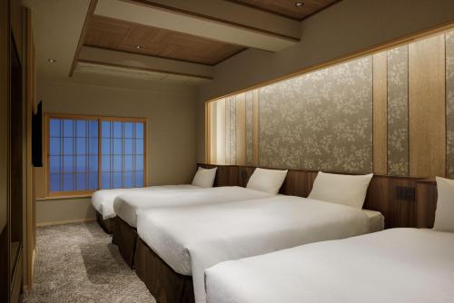 a row of beds in a room at Laforet Shuzenji Sanshisuimei in Izu
