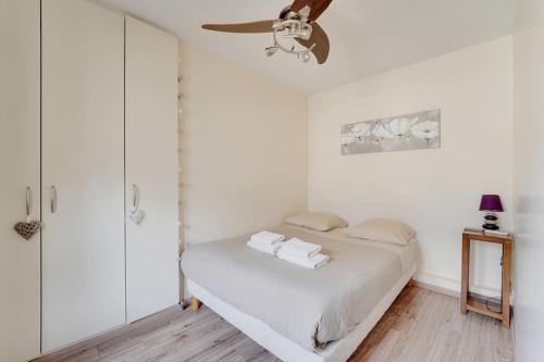 une chambre blanche avec un lit et un ventilateur de plafond dans l'établissement Charming suite close to Grand Rex, à Paris