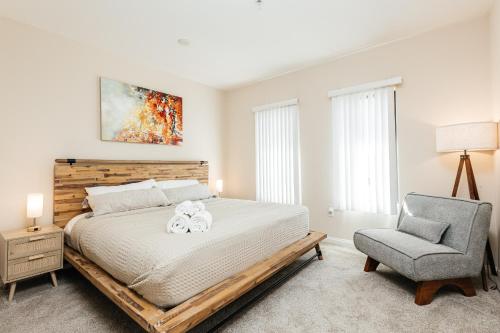 a bedroom with a large bed and a chair at Luxury One Bedroom minutes from The Grove in Los Angeles