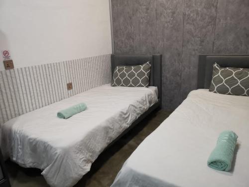 two beds sitting next to each other in a room at Kota Permai Free n Easy Interior Bukit Mertajam in Bukit Mertajam