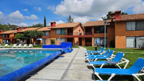 una fila de tumbonas azules junto a una piscina en Villa 25 La Rinconada Tequisquiapan, en Tequisquiapan