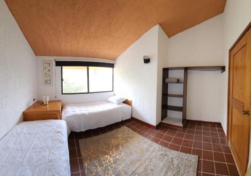 Un dormitorio con dos camas y una ventana. en Villa 25 La Rinconada Tequisquiapan, en Tequisquiapan