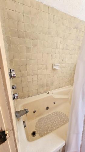 a bath tub in a bathroom with a shower curtain at Villa 25 La Rinconada Tequisquiapan in Tequisquiapan