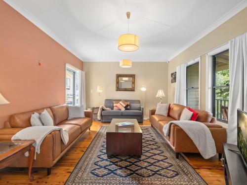 a living room with couches and a table at Scenic Cottage in Katoomba
