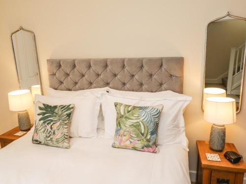 a bedroom with a white bed with two pillows at Crossing Cottage in Whitby