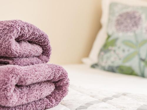 a pile of purple towels sitting on a bed at Crossing Cottage in Whitby