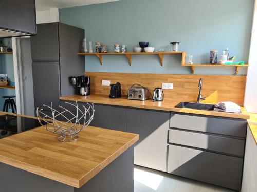 - une cuisine avec un comptoir en bois et un évier dans l'établissement Baradozic le petit paradis à Melon, à Porspoder