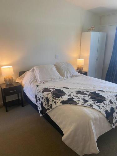 a bedroom with a black and white bed with two lamps at Unit A9, Adorable holiday unit with stunning views in Otematata
