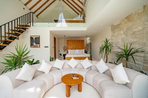 een woonkamer met een witte bank en een bed bij 7Seas Bingin in Uluwatu