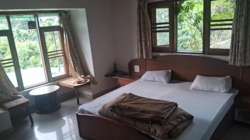 a bedroom with a bed with a blanket on it at Experto The Greens in Nainital