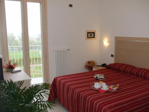 a hotel room with a bed with a red blanket at Residence Hotel Matilde in Carpineti