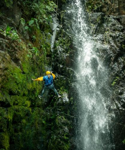 a man is rappelling off of a waterfall at Ecoterra Inka Lodge Shared Rooms in Quillabamba