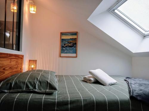 une chambre avec un lit et une lucarne dans l'établissement Les studios de la gare linge café thé inclus wifi, à Vannes