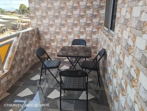 un patio con mesa y 4 sillas en Résidence Meublée Smart 2, en Man