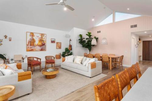 Una sala de estar con sofás y un comedor. en Luxe Modern Waterfront 4BR Oasis Wifi, BBQ & Pool, en Gold Coast